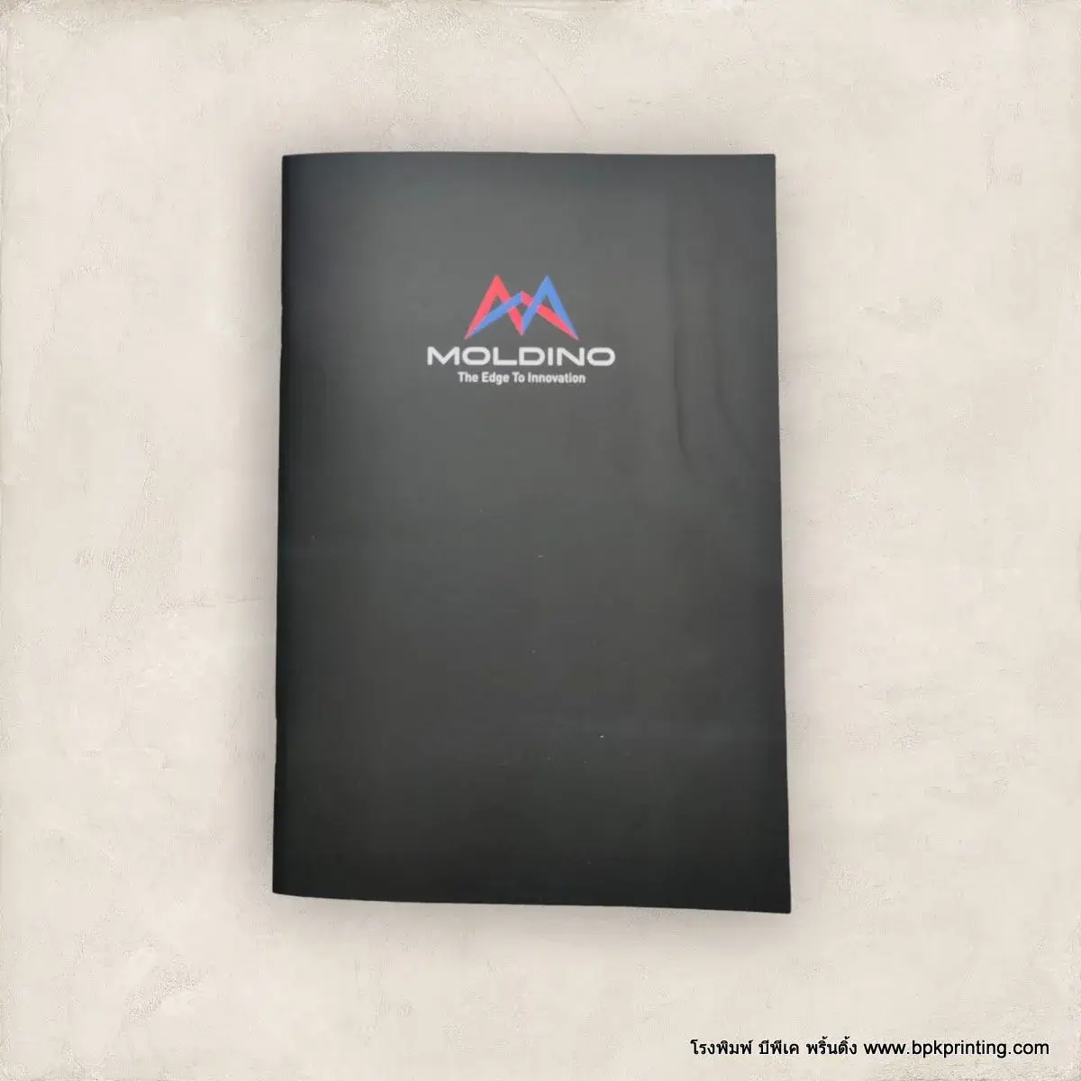 สมุดโน้ตพรีเมียมปกสีดำ MOLDINO พร้อมโลโก้และสโลแกน The Edge to Innovation พิมพ์ระบบคุณภาพจากโรงพิมพ์ BPK Printing เหมาะสำหรับแจกในงานอีเวนต์ งานสัมมนา และใช้ในองค์กร เพิ่มภาพลักษณ์แบรนด์ให้ดูมืออาชีพด้วยงานพิมพ์คุณภาพสูงจากโรงพิมพ์ครบวงจร