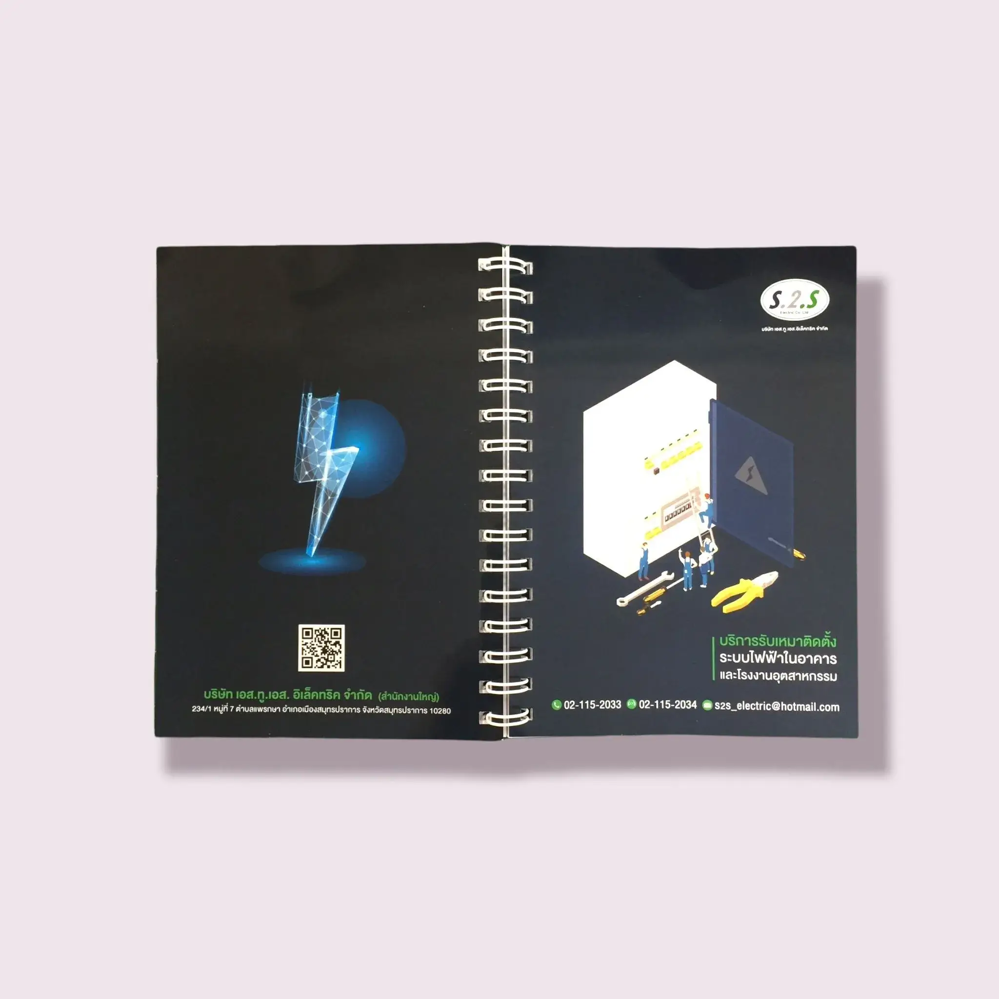 สมุดโน้ตสันห่วงออกแบบเฉพาะสำหรับบริษัท S2S Electric พิมพ์ภาพกราฟิกเกี่ยวกับระบบไฟฟ้าในอาคารและอุตสาหกรรม พร้อมโลโก้และข้อมูลติดต่อครบถ้วน โรงพิมพ์ BPK Printing รับผลิตสมุดโน้ตบริษัท พิมพ์โลโก้และดีไซน์เฉพาะแบรนด์ เสริมภาพลักษณ์องค์กรด้วยงานพิมพ์คุณภาพสูง